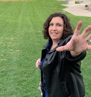 一位女士站在田野里,举着手