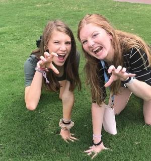 two girls laying on the grass in the grass