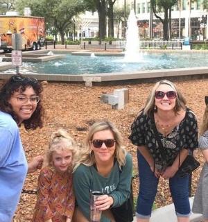 a group of people standing in front of a fountain