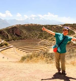 a woman standing on top of a hill with her arms out