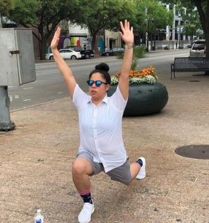 a man is dancing on a sidewalk with his hands in the air