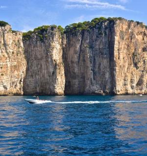 loď ve vodě vedle velkého útesu