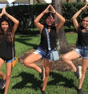 三个女孩在一棵树前做瑜伽姿势