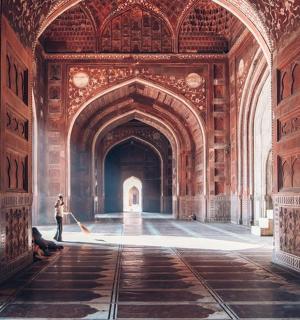 站在建筑物拱门里的人