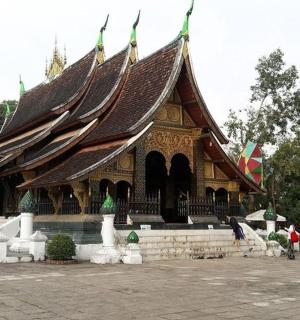 a large building with a roof with people standing around it