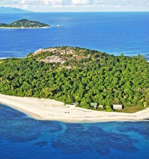 an island in the ocean with a boat on it
