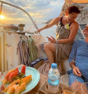 Ein Mann und eine Frau sitzen mit einem Obstteller auf einem Boot