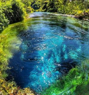 a large pool of blue water in a river