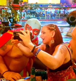 a man taking a picture of a woman with a mask