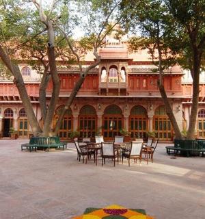 a courtyard with tables and chairs in front of a building