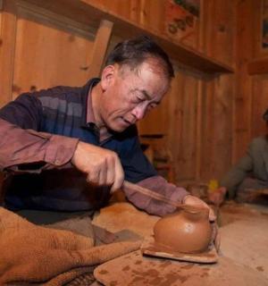 一名男子在陶轮上制作陶罐