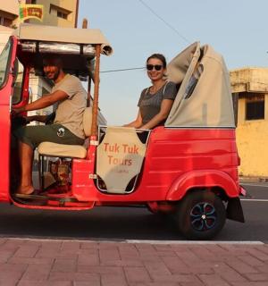two people riding a small red golf cart