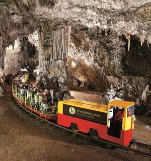 a small train in a cave with people on it