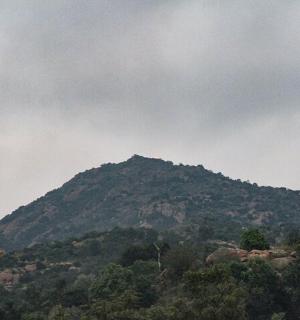 a mountain in the middle of a cloudy sky