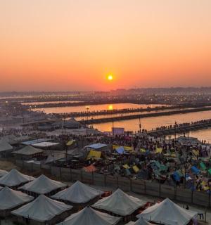 一群人站在水边，带着帐篷