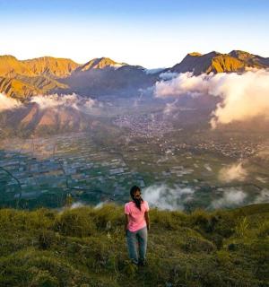 a woman standing on top of a hill overlooking a valley