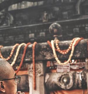 一位戴眼镜的男子站在墙前