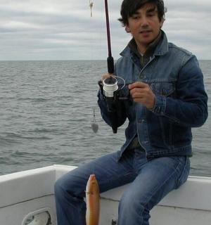 a man sitting on a boat holding an umbrella