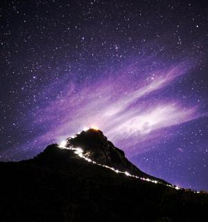a mountain under a night sky with a star filled sky
