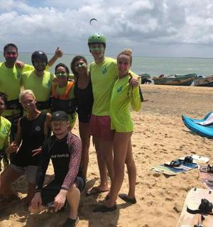 a group of people posing for a picture on the beach