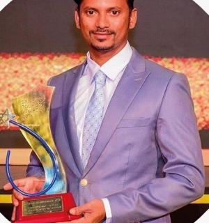 a man in a purple suit holding a trophy