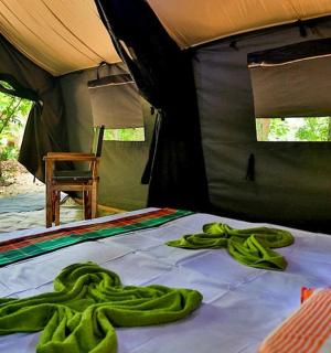 a bed in a tent with green towels on it