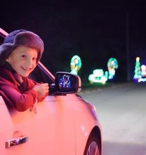 a young child looking at a side view mirror of a car