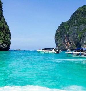 a group of boats in the water near a beach
