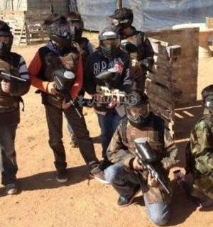 skupina mužů pózujících pro fotografii se zbraněmi