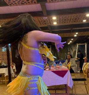 一位穿着连衣裙的女士站在桌子前