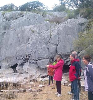 一群人站在一块大石头前