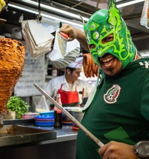 a man wearing a mask in a kitchen preparing food