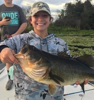 一个男孩手里拿着一条大鱼