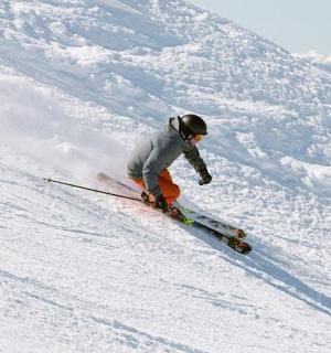 一个人正在从积雪覆盖的斜坡上滑雪下来