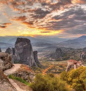 a man standing on top of a mountain looking at a valley