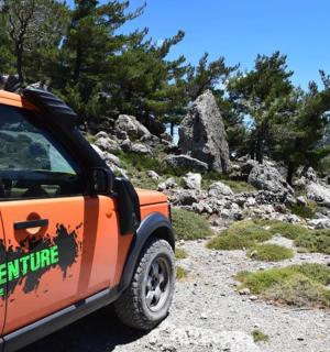 一辆橙色的汽车停在岩石小路上