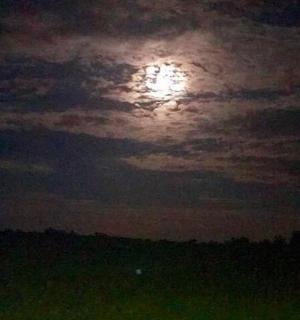 a full moon in a cloudy sky at night