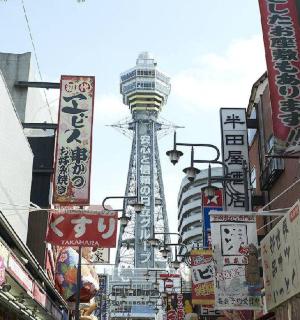 a city street with many signs and a tower