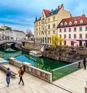a group of people walking on a bridge over a river