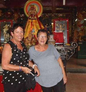 两位老年妇女站在寺庙前