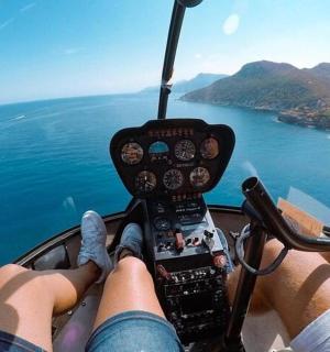 驾驶直升机飞越水面的人