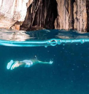 在悬崖附近的水中游泳的人