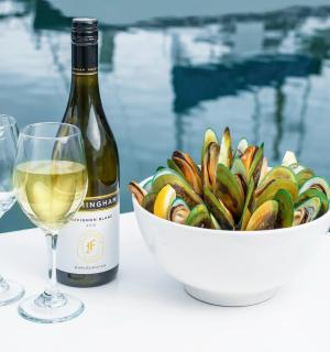 a bottle of wine and a bowl of pasta and two glasses