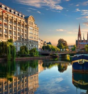 a river in a city with a building and a boat