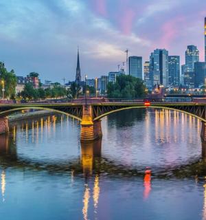 eine Brücke über einen Fluss mit einer Stadt im Hintergrund