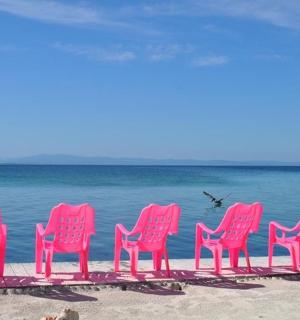a group of pink chairs sitting on the beach