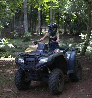 a young child riding on a atv in the woods