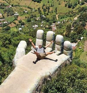 a man is laying on top of a giant hand