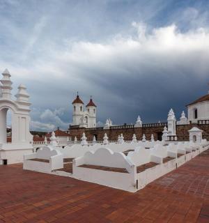 a white building with two churches in the background