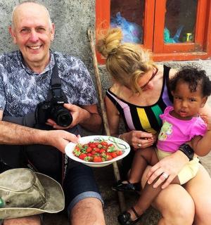 一个男人、一个女人和一个孩子，手里拿着一盘水果